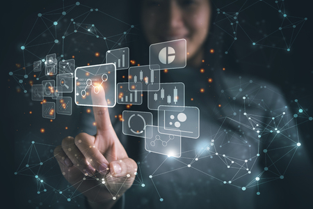 Big data analytics and business intelligence concept with chart and graph icons on a digital screen interface and a businesswoman in backgroundの写真素材