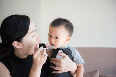 Mom is feeding her baby.They are Asian.の写真素材