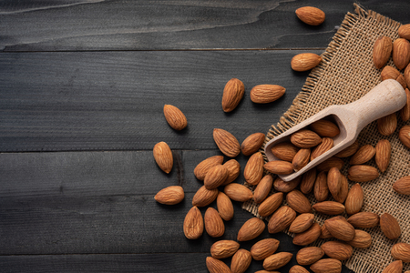 Almonds on dark wooden table. Almond concept.top view.の写真素材
