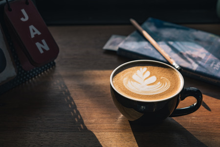 Cup of coffee latte with beautiful latte art on wood table backgroundの写真素材