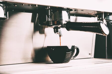 Espresso machine making coffee with cup in coffee shop.