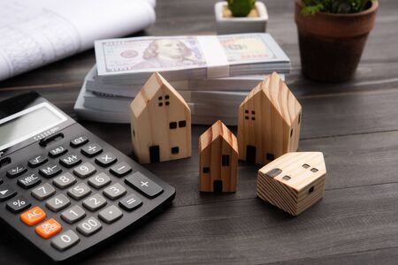 Small four wooden houses with modern design and calculator for home loans concept.の写真素材