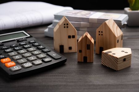 Small four wooden houses with modern design and calculator for home loans concept.の写真素材