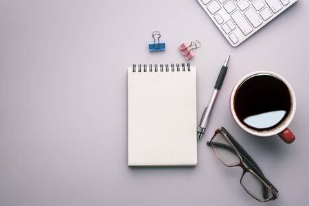 Flat lay, top view office table desk. Workspace with keyboard, office supplies, pencil,and coffee cup on gray background.の写真素材