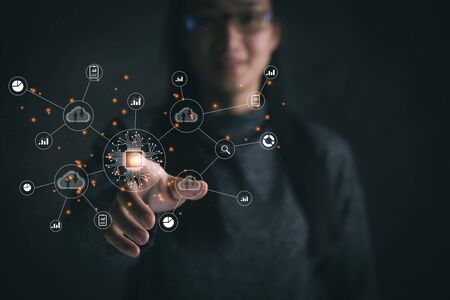 Big data analytics and business intelligence concept with chart and graph icons on a digital screen interface and a businesswoman in backgroundの写真素材