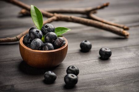 Blueberry on dark wooden table. Blueberries in wooden bowl, Blue berry detailの写真素材