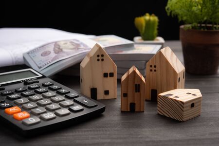 Small four wooden houses with modern design and calculator for home loans concept.の写真素材