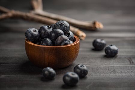 Blueberry on dark wooden table. Blueberries in wooden bowl, Blue berry detailの写真素材