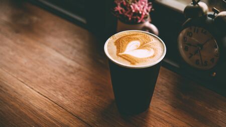Cup of coffee latte with beautiful latte art on wood table backgroundの写真素材