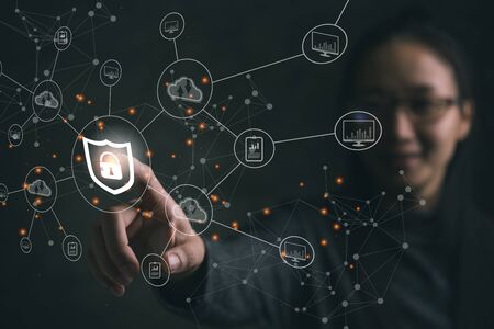 Businesswoman pressing shield protect icon on virtual screen, Concept cyber security safe your data.の写真素材