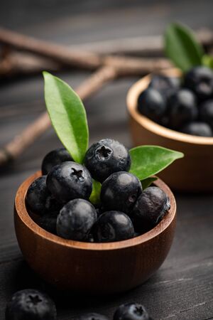 Blueberry on dark wooden table. Blueberries in wooden bowl, Blue berry detailの写真素材