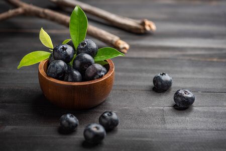 Blueberry on dark wooden table. Blueberries in wooden bowl, Blue berry detailの写真素材