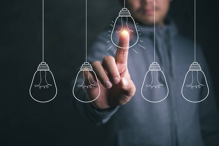 Businessman pointing light bulbの写真素材