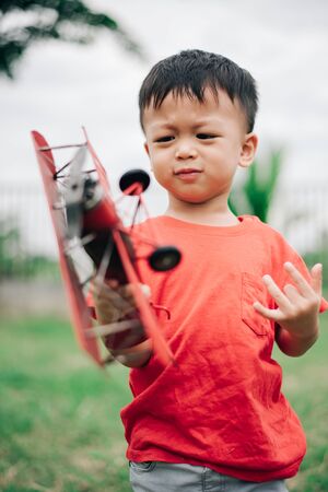 Boys are playing fun with toy planes At the garden in the house.Boys wearing red shirtsの写真素材
