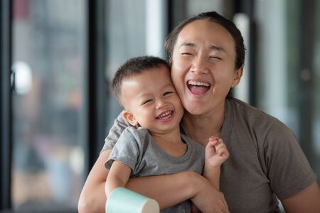 Portrait of woman relaxing at home with her little boy.の写真素材