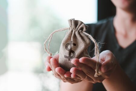 Women hand hold a money bag, a loan or saving money for future investment concept.