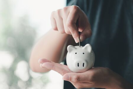 Hand putting coin on piggy bank.の写真素材
