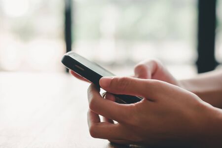 woman's hands are using a smartphone at home.の写真素材