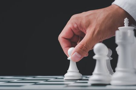 Businessman hand play with chess game. concept of business strategy and tactic.strategy, management or leadership conceptの写真素材
