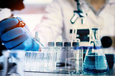 Scientist with equipment and science experiments ,laboratory glassware containing chemical liquid for design or decorate your content,copy space.Pipette dropping a sample into a test tubeの写真素材