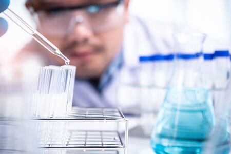 Scientist with equipment and science experiments ,laboratory glassware containing chemical liquid for design or decorate your content,copy space.Pipette dropping a sample into a test tubeの写真素材