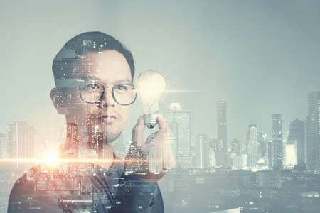 double exposure of businessman holding light bulb. idea concept with innovation and inspiration Creativity and innovative are keys to success.Concept of new idea and innovation with light bulbs.の写真素材