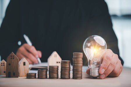 businessman holding lightbulb and use calculator. concept saving money and finance accounting for the future.idea innovation.の写真素材