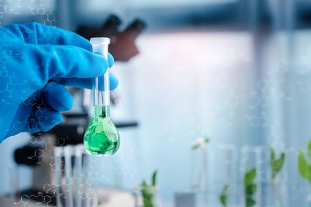 Scientist hand holding chemical flask with liquid.biotechnoloy research concept.Natural extractsの写真素材