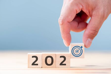hand is putting wooden cubes with New year 2020 and goal icon. Concept for success in the future goal and passing time. Happy new year.の写真素材
