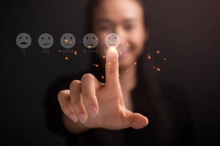 Businesswoman pressing smiley face touch screen . Business Service Satisfaction conceptの写真素材