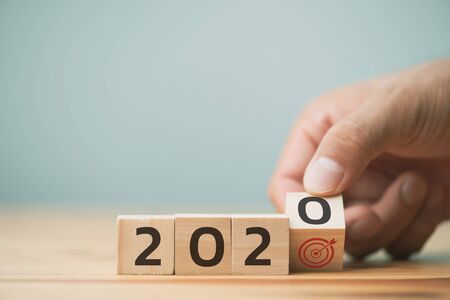 hand is opening wooden cubes with New year 2020 and goal icon. Concept for success in the future goal and passing time. Happy new year.の写真素材