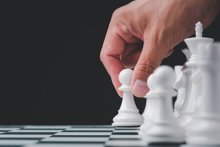 Businessman hand play with chess game. concept of business strategy and tactic.strategy, management or leadership conceptの写真素材