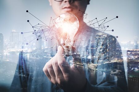 double exposure of businessman holding light bulb. idea concept with innovation and inspiration Creativity and innovative are keys to success.Concept of new idea and innovation with light bulbs.の写真素材