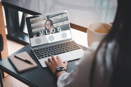 video blog, woman reading vlog online on computerの写真素材