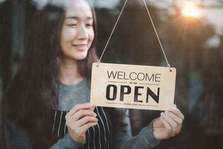 Beautiful woman of asian opening shop.