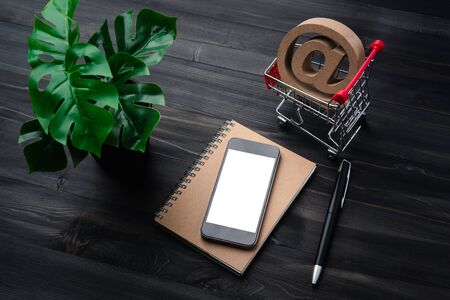 Creative workspace modern dark office desk with blank smartphone and pen on notebook,mockup topviewの写真素材