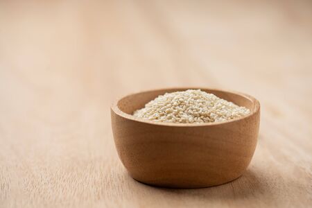 close up of white sesame seed in wooden bowl with copy space.の写真素材