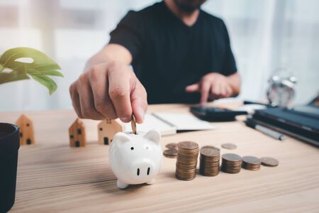 man hand putting coin on piggy bank.saving and financial planning concept.の写真素材