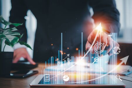 businessman using tablet analyzing sales data and economic growth graph chart .e-commerce and network, business strategy. digital marketing.planning business and financial conceptの写真素材