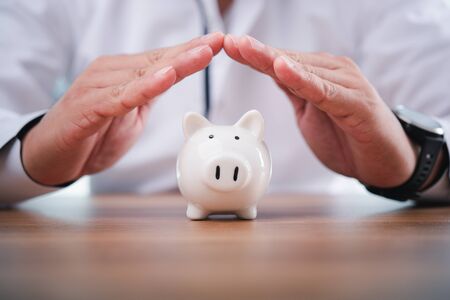 Businessman take a position to protect the piggy bank in hand.Concept of protection of business assets and finance.の写真素材