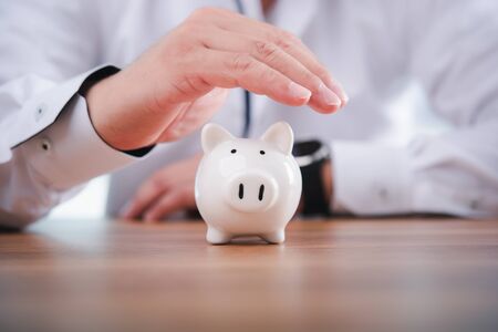 Businessman take a position to protect the piggy bank in hand.Concept of protection of business assets and finance.の写真素材