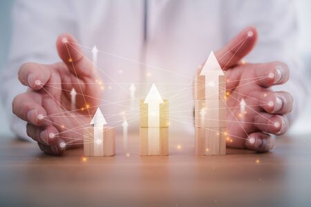 Business development to success and growing growth concept.businessman try to arrange wooden blocks into growing graphs.の写真素材