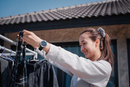 Beautiful Thai woman is drying clothes.housewife doing housework concept.の写真素材