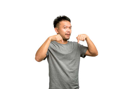 good looking young Asian man smiling with his pointed finger to the Down below on white background.の写真素材