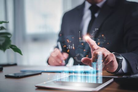 businessman use tablet plans to increase business growth and an increase in the indicators of positive growth in 2020 on virtual screen.の写真素材