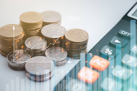coins and calculator with graph , stationary and rows of coins for goal office , finance and business investment concept background.の写真素材