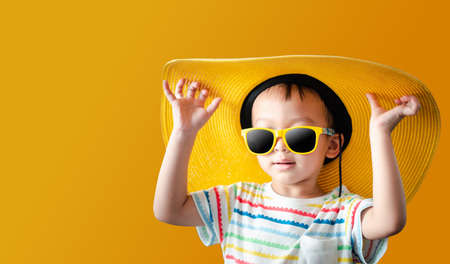 portrait kids with yellow background Summer concept is coming.cute asian boys 3 years old.の写真素材