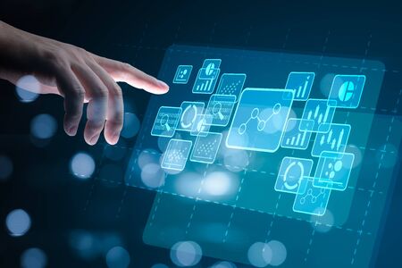 Big data analytics and business intelligence concept with chart and graph icons on a digital screen interface and a businessman hand in backgroundの写真素材