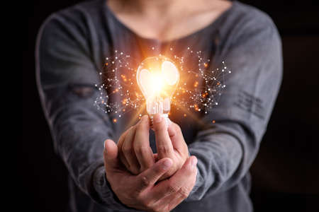 Hand of man holding illuminated light bulb, idea, innovation and inspiration concept.concept...