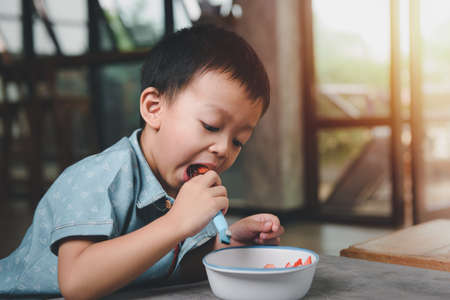 Portrait asian Boy 3 years old Smiling happily While eating snacks. The joy of eating for children concept.の写真素材